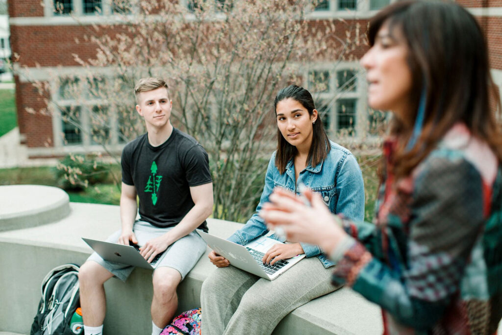 A professor presenting to students in an outdoor classroom